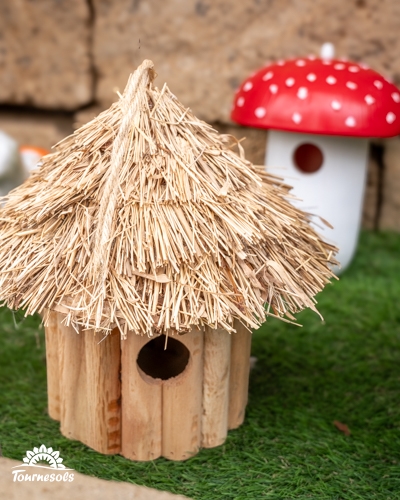 Nichoir en bois en forme de hutte au toit de paille